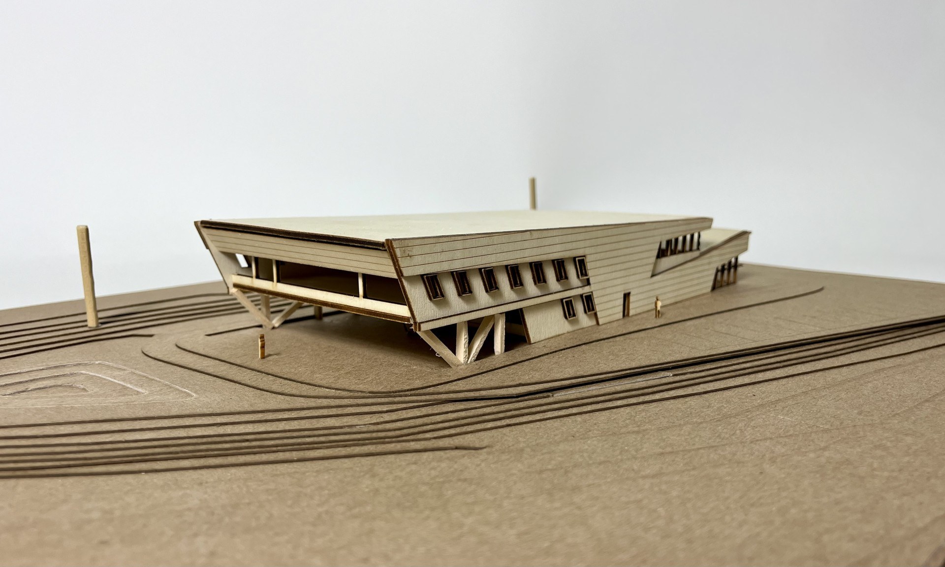 Physical study model of the LSU Campus Health Center, showing the large sloping upper volume cantilevering over the open ground level