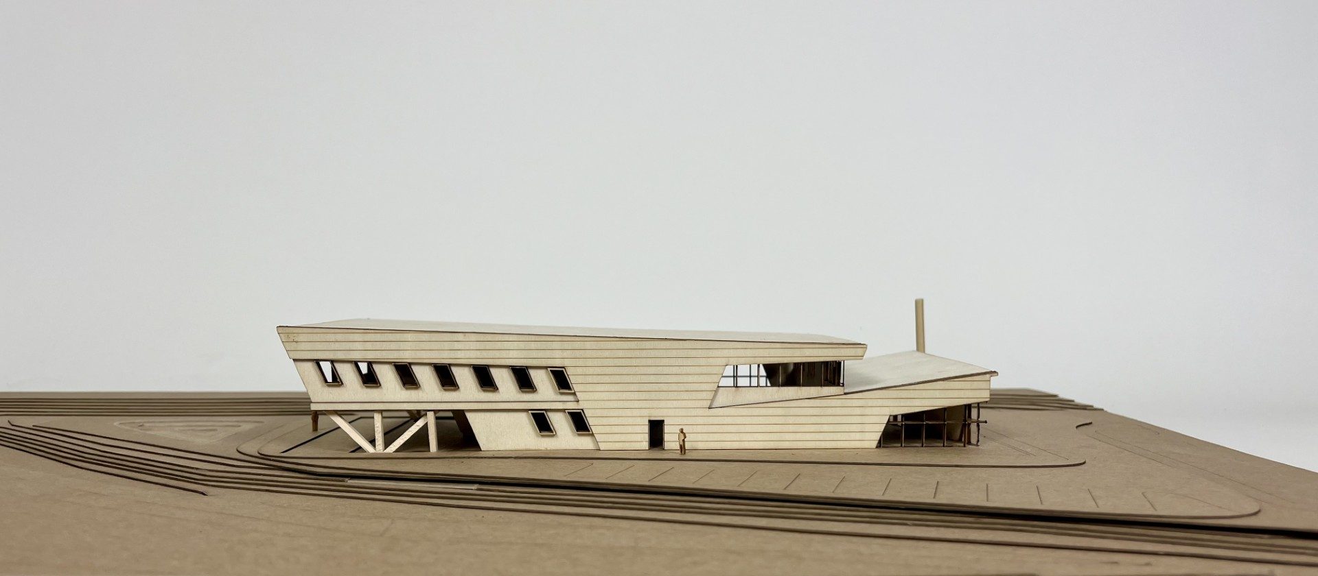 Side view of the LSU Campus Health Center study model, showing the sloping upper volume and structural supports beneath
